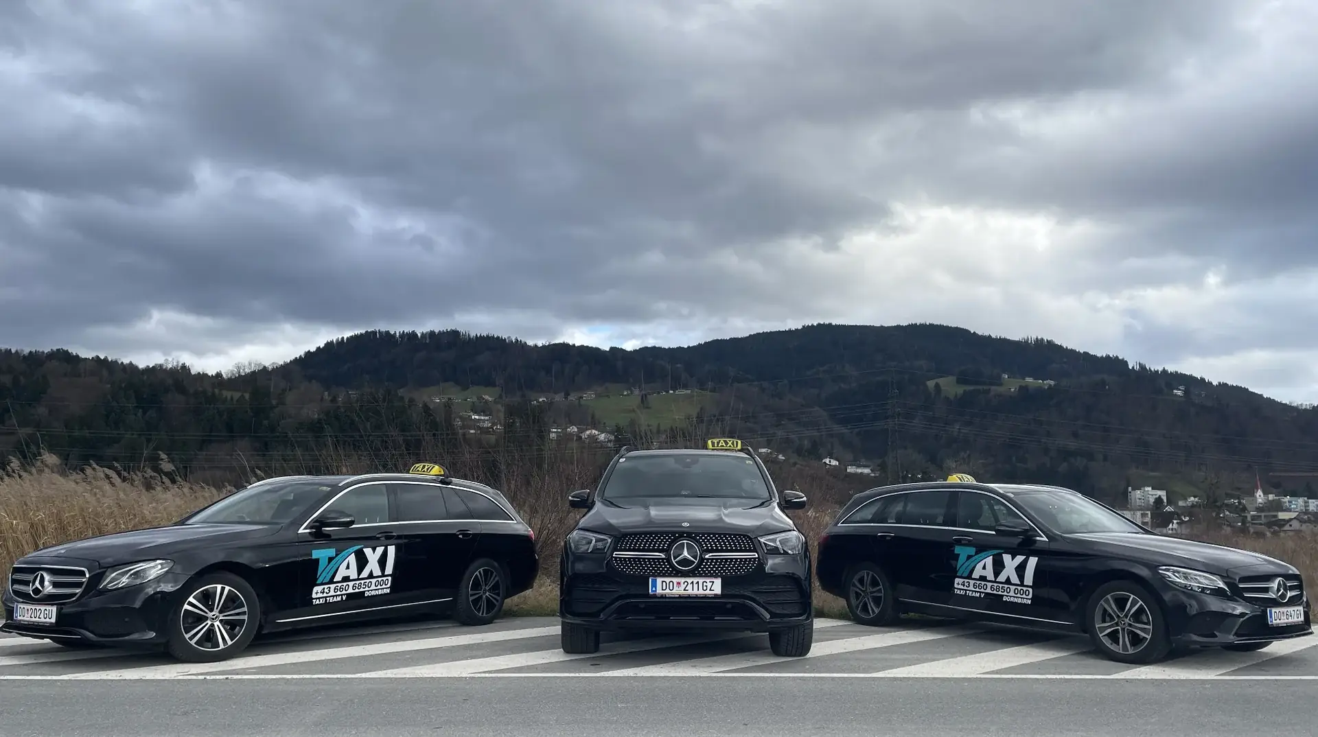 Drei Taxis von Taxi Team V vor Bergkulisse in Dornbirn